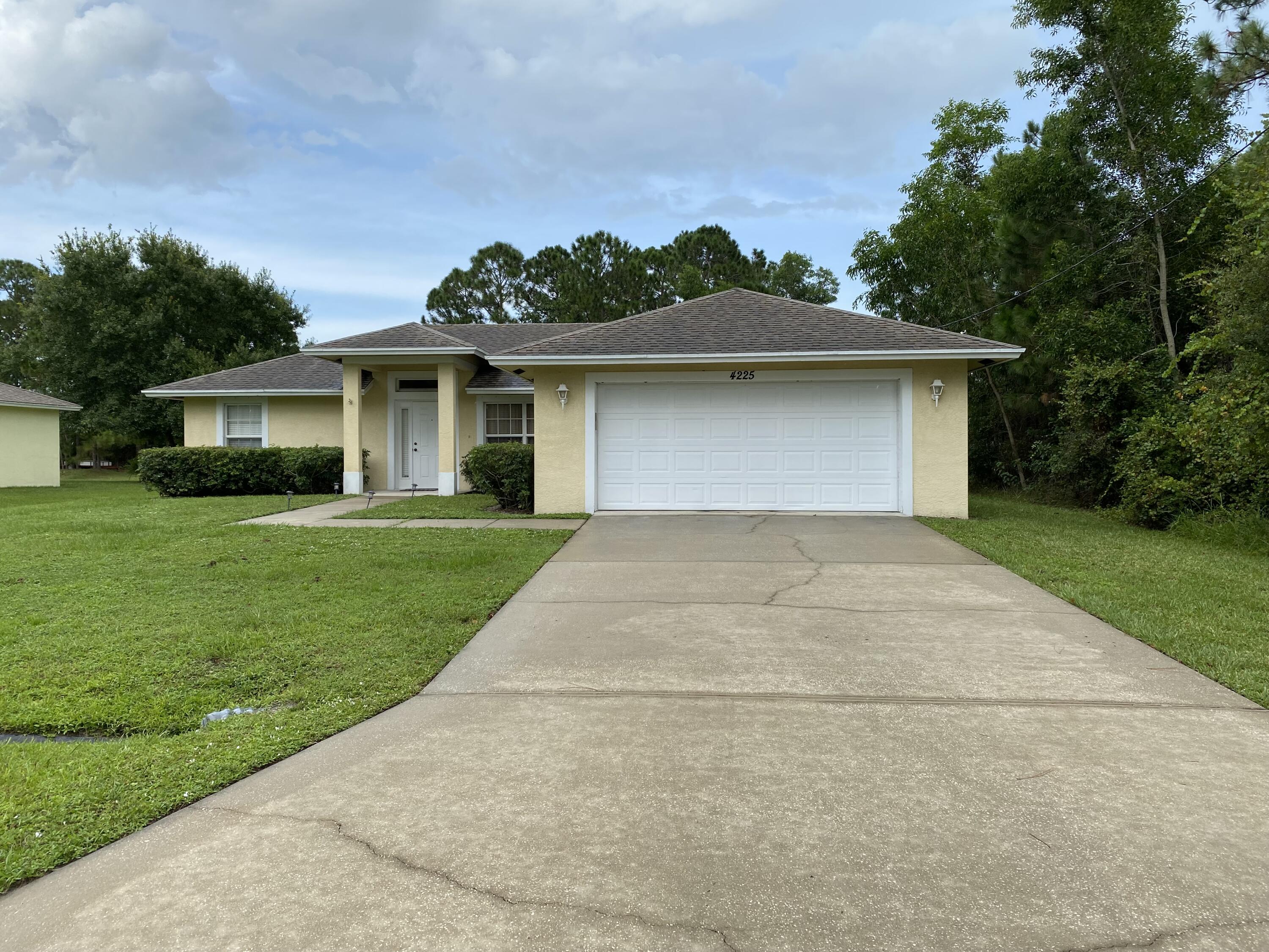 4225 Southwest Daemon Street Port St. Lucie, FL 34953 - Photo 1 of 2 a front view of house with yard and green space