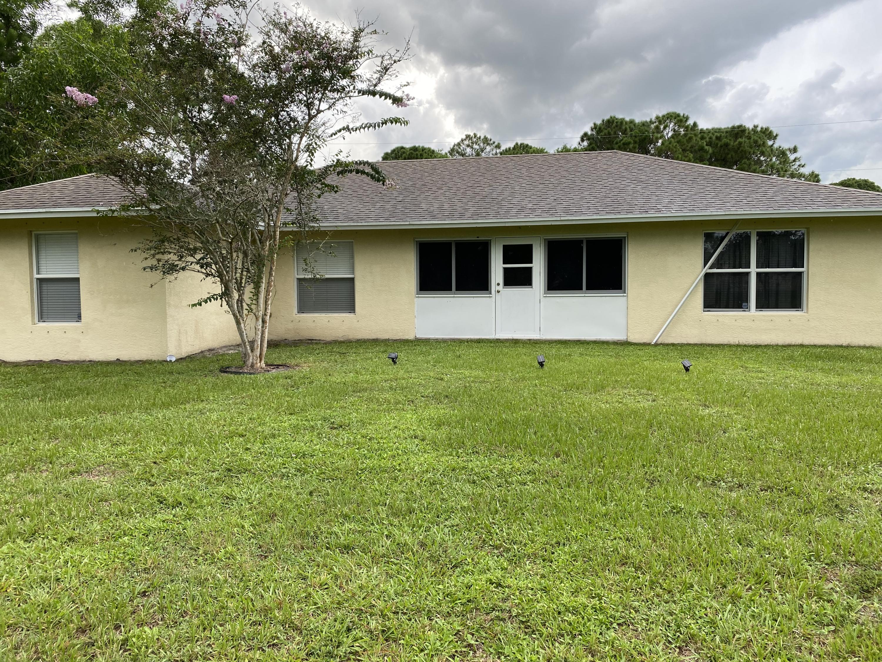 4225 Southwest Daemon Street Port St. Lucie, FL 34953 - Photo 2 of 2 a front view of a house with yard and garage