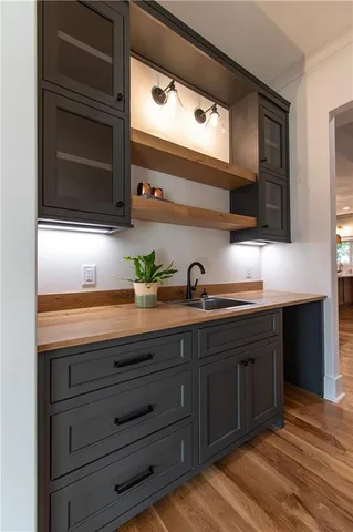 a living room with stainless steel appliances furniture a fireplace and cabinets