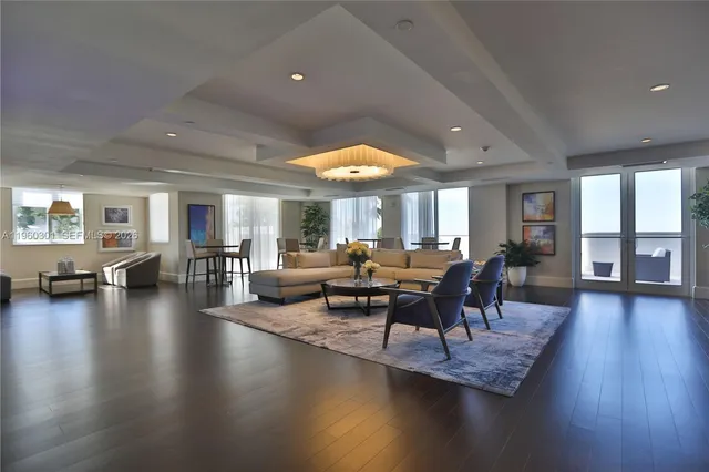 a living room with couches and a dining table with wooden floor