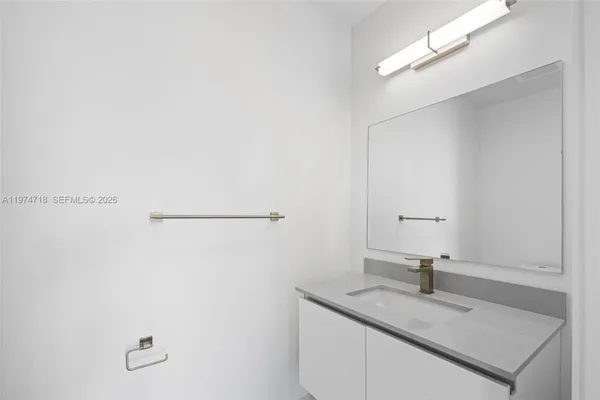 a bathroom with a granite countertop sink a toilet and shower