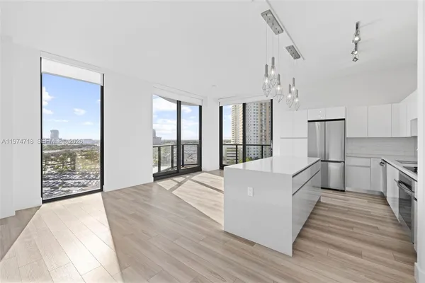 a living room with stainless steel appliances furniture and a large window