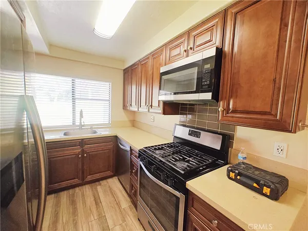 a kitchen with stainless steel appliances a stove sink and microwave