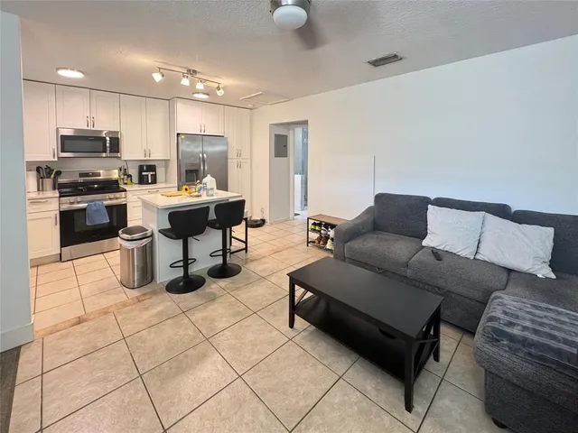 a living room with furniture and kitchen view