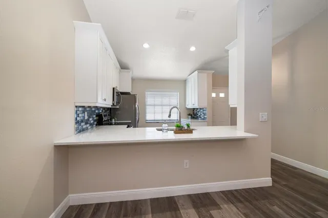 a kitchen with kitchen island a sink and wooden floor