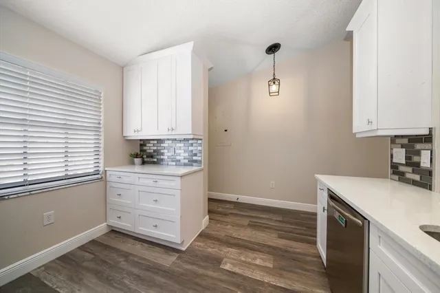 a kitchen with granite countertop white cabinets and white appliances