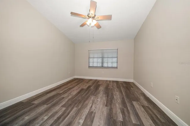 an empty room with a window and a ceiling fan