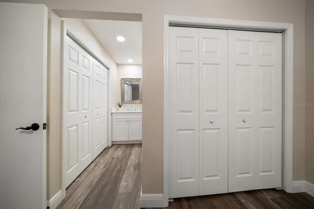 a view of a hallway with wooden floor and closet