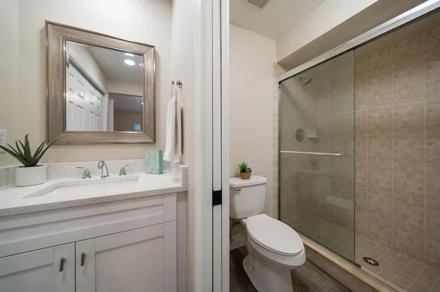 a bathroom with a granite countertop toilet sink and shower