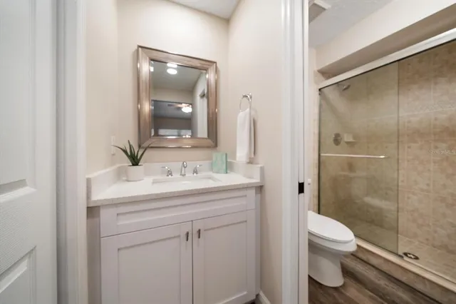 a bathroom with a granite countertop sink toilet and shower