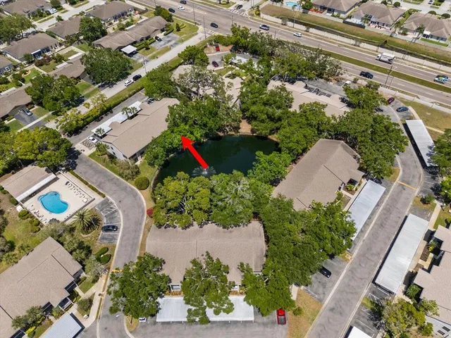an aerial view of a house with a yard and tennis court