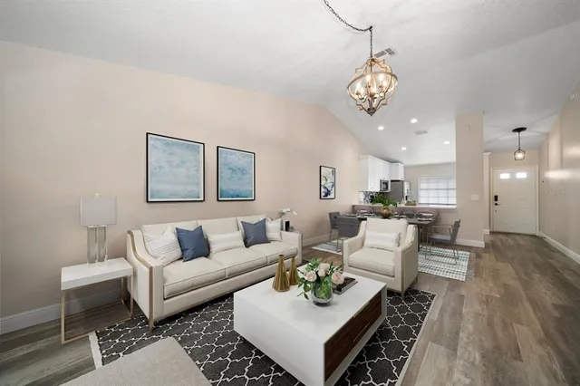 a living room with furniture a couch and kitchen view