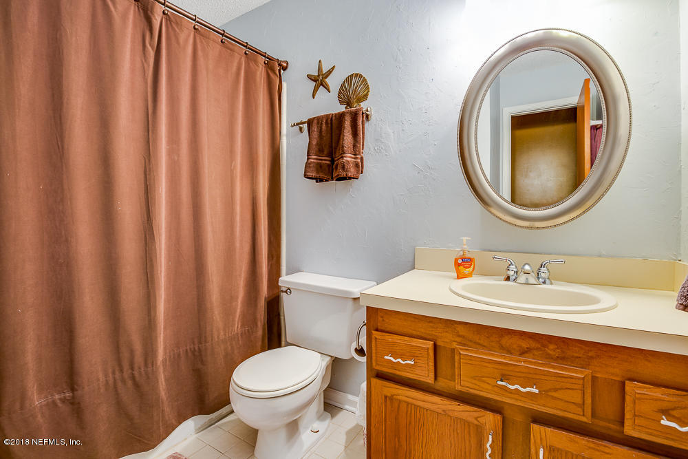 1866 Clemson Road Jacksonville, FL 32217 - Photo 15 of 21 a bathroom with a toilet sink vanity and mirror
