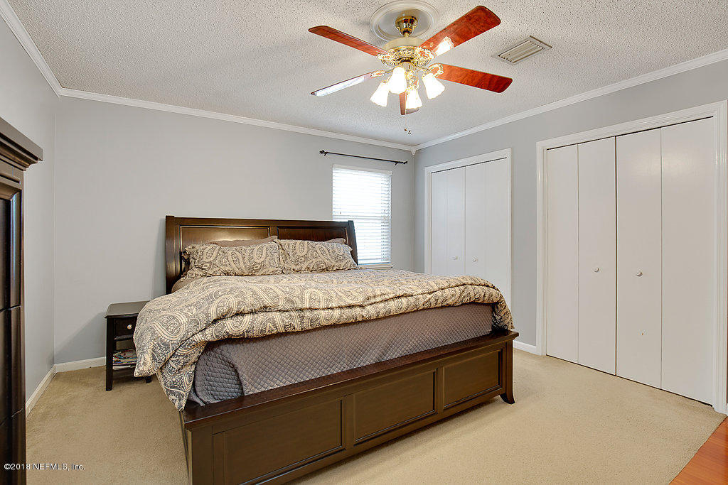 1866 Clemson Road Jacksonville, FL 32217 - Photo 16 of 21 a spacious bedroom with a bed and a chandelier