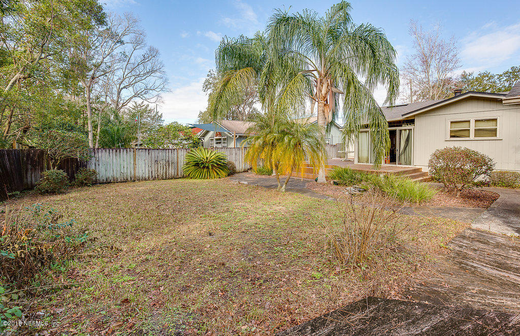 1866 Clemson Road Jacksonville, FL 32217 - Photo 20 of 21 a backyard of a house with table and chairs under an umbrella