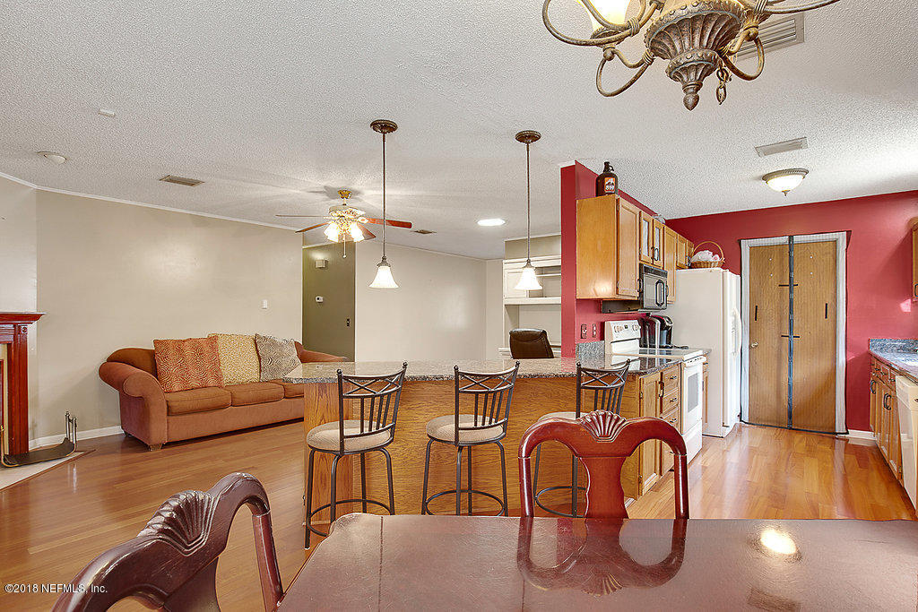 1866 Clemson Road Jacksonville, FL 32217 - Photo 6 of 21 a living room with furniture a chandelier and a wooden floor
