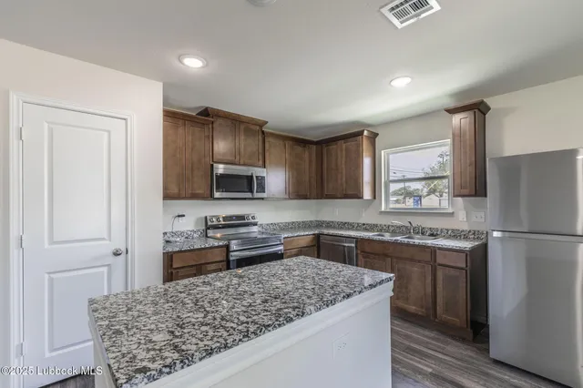 a kitchen with a stove a refrigerator and a sink