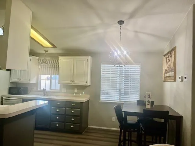 a kitchen with a table chairs a sink dishwasher window and cabinets