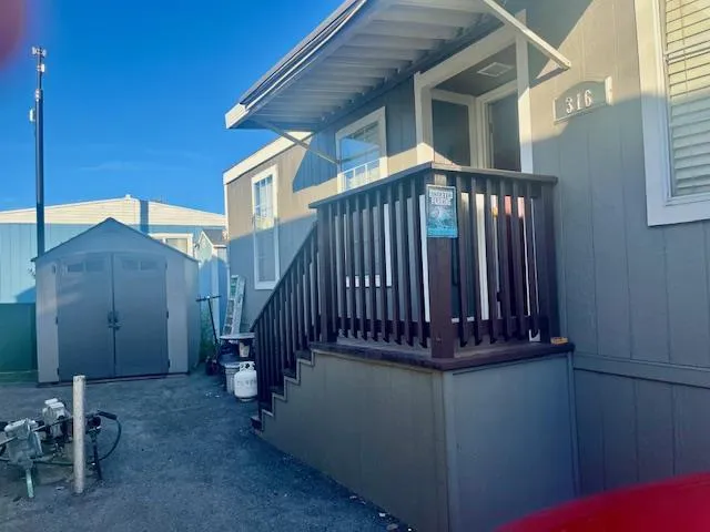 a view of a house with a small deck and wooden floor