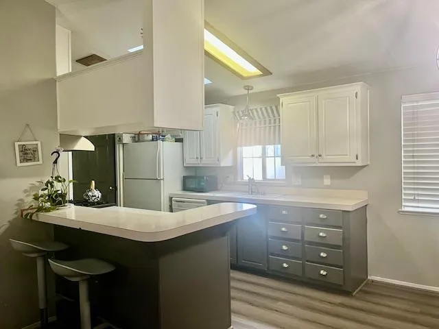 a kitchen with a sink cabinets and wooden floor
