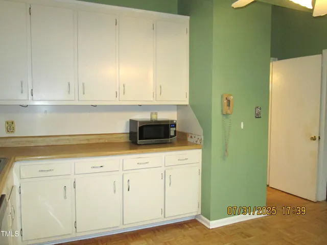 a kitchen with white cabinets and sink