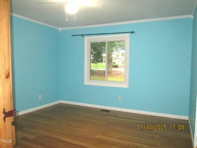 an empty room with a window and ceiling fan