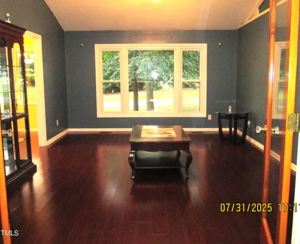 a view of a livingroom with furniture wooden floor and a large window