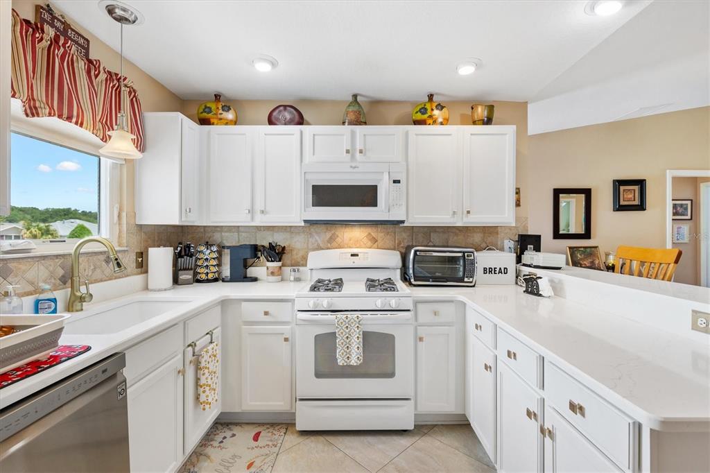 470 Oboe Way The Villages, FL 32162 - Photo 5 of 42 a kitchen with stainless steel appliances granite countertop a sink and cabinets