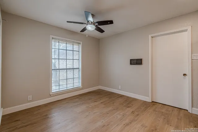 a view of an empty room with wooden floor