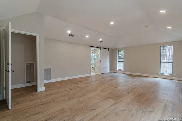 a view of empty room with wooden floor