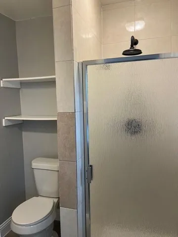 a bathroom with a toilet and a shower