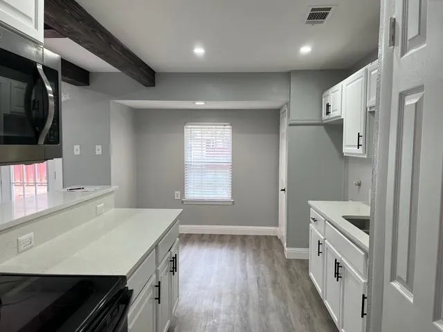 a kitchen with a sink a refrigerator and cabinets