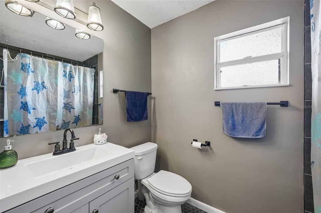 10303 Fordham Street Spring Hill, FL 34608 - Photo 13 of 25 a bathroom with a toilet a sink and mirror