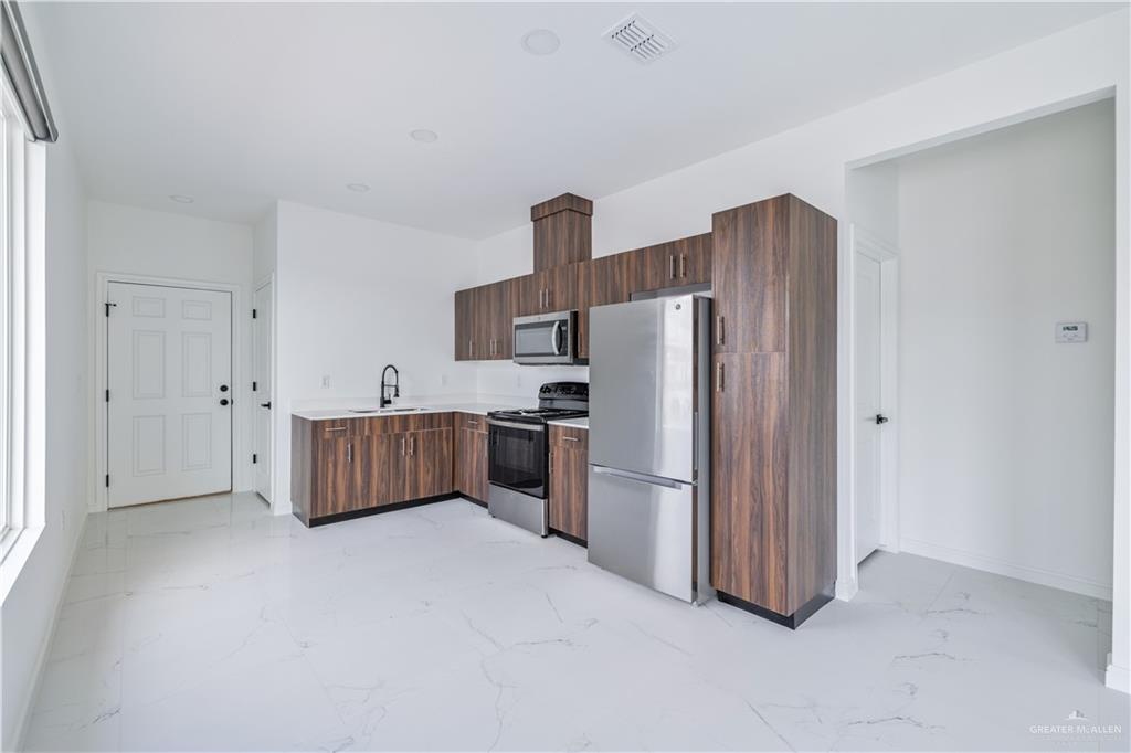 5322 Vision Street Rio Grande City, TX 78582 - Photo 5 of 20 a kitchen with refrigerator cabinets and a refrigerator