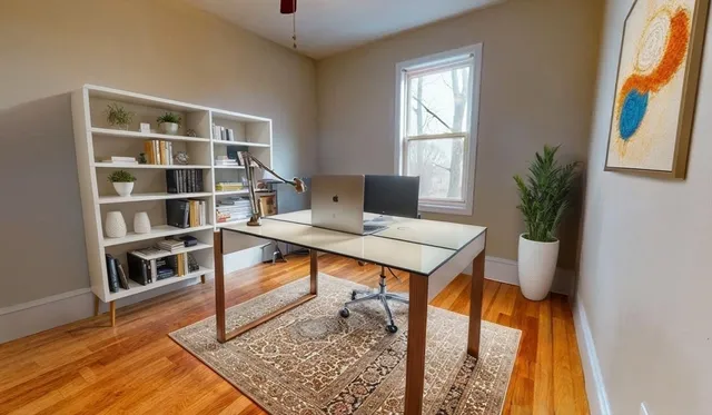 a view of a workspace with furniture and a window