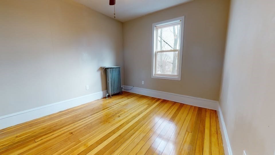 75 Cherry Street, Unit 2 Malden, MA 02148 - Photo 12 of 17 a view of an empty room with wooden floor and a window