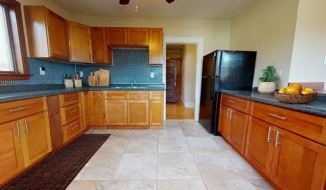 a kitchen with stainless steel appliances granite countertop a refrigerator and a sink