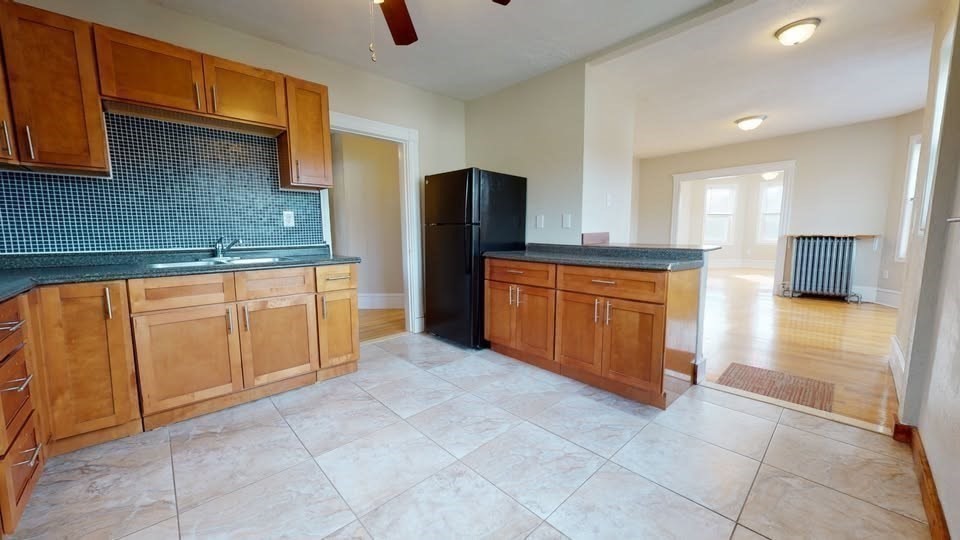 75 Cherry Street, Unit 2 Malden, MA 02148 - Photo 14 of 17 a large kitchen with stainless steel appliances granite countertop a stove a sink and a microwave