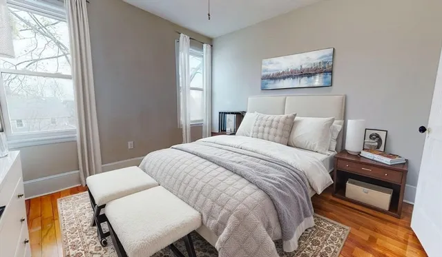 a bedroom with a bed and wooden floor