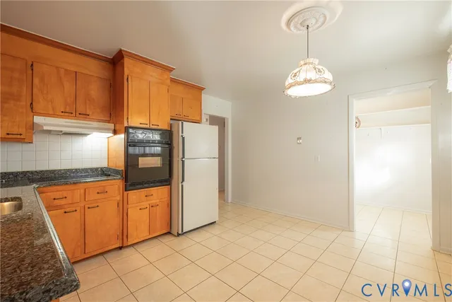 a kitchen with stainless steel appliances granite countertop a refrigerator a stove and a sink with granite countertops