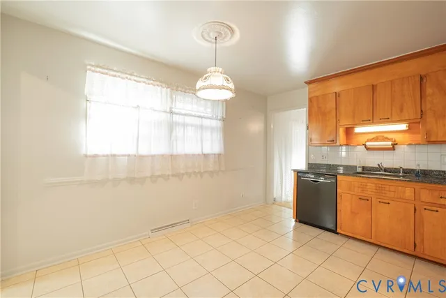 a kitchen with granite countertop a stove a sink and a refrigerator