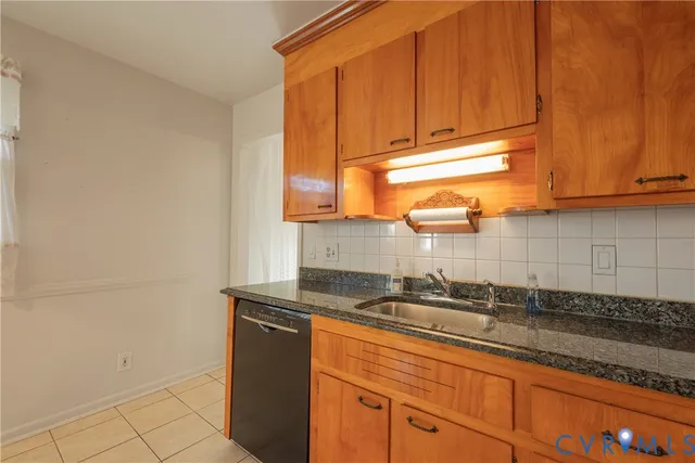 a kitchen with granite countertop a sink and a white cabinets