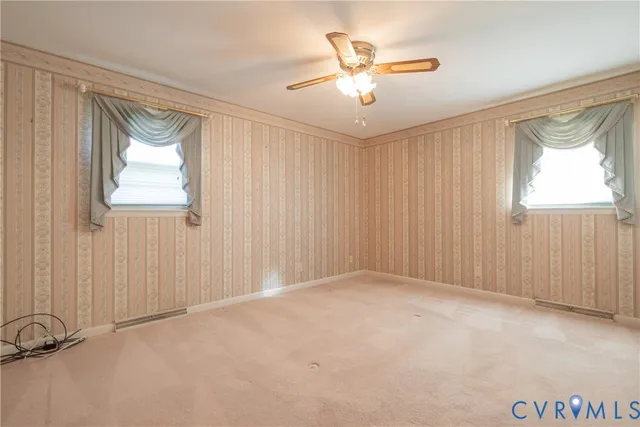 an empty room with windows and fan