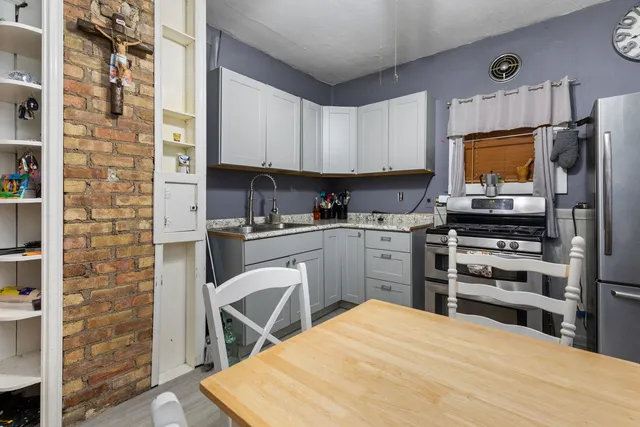a kitchen with stainless steel appliances kitchen island granite countertop a refrigerator stove and sink