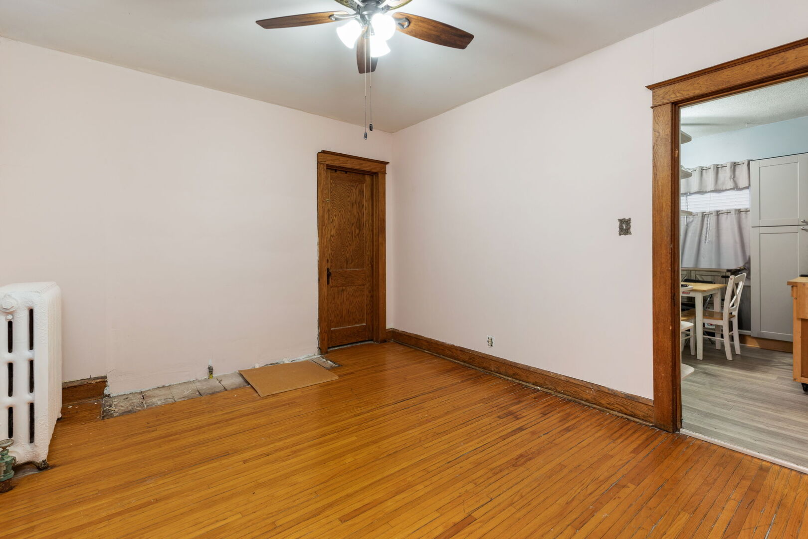 610 Watson Street Aurora, IL 60505 - Photo 7 of 15 an empty room with wooden floor chandelier fan and windows
