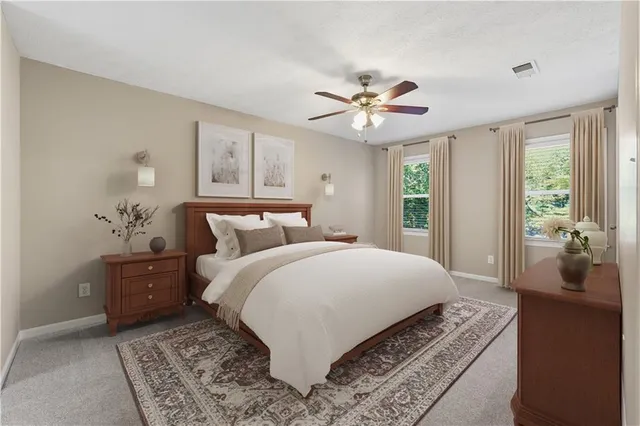 a spacious bedroom with a large bed and a chandelier