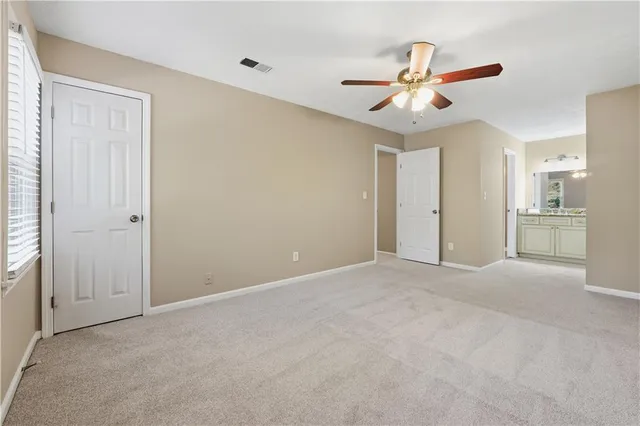 an empty room with a ceiling fan and a window