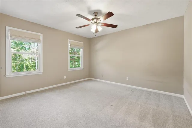 an empty room with a window and a ceiling fan