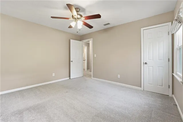 an empty room with a ceiling fan and a window
