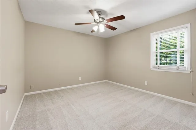 an empty room with a window and a ceiling fan